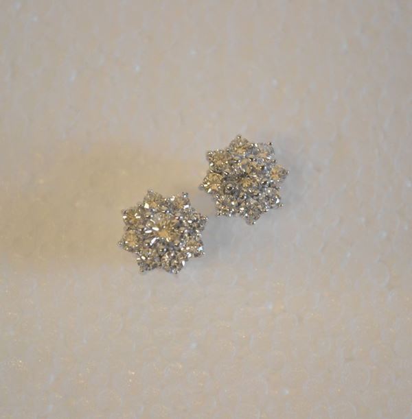 Paio di orecchini in oro bianco e diamanti                                  ciascuno modellato come una corolla decorata in brillanti per complessivi   ct 2 circa, g 4                                                            (2)