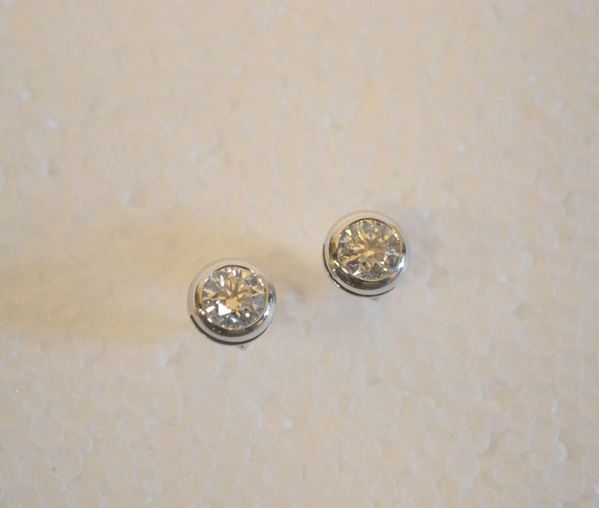 Paio di orecchini 'punto luce' in oro bianco e diamanti                     ciascuno realizzato con un brillante montato entro castone ad anello per    complessivi                                                                 ct 1,40 circa                                                             (2)