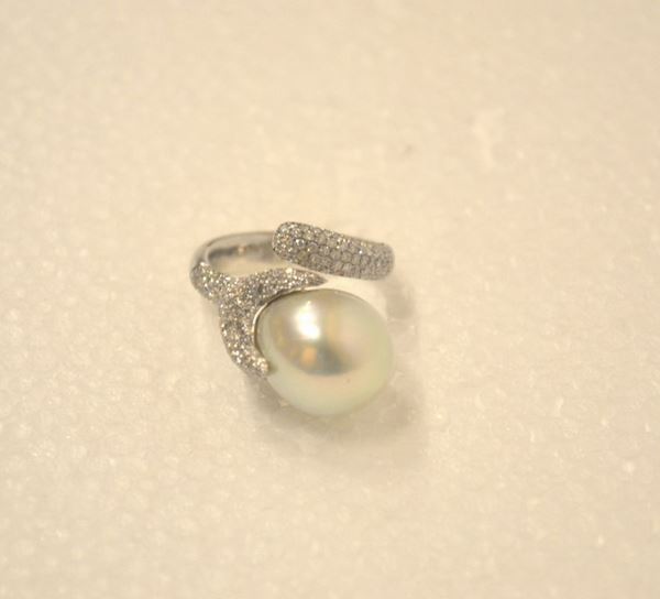 Anello in oro bianco, perla South Sea e diamanti                            montatura contrariÃ¨ decorata ad un estremitÃ  da un pavÃ¨ di brillanti e      dall'altra da una bacca stilizzata in pavÃ¨ di brillanti e perla diam mm 13
