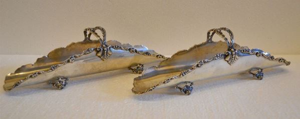 Coppia di porta grissini, in argento, bordi sbalzati a volute, quattro      piedini traforati, lungh. cm 30, g 570 (2)