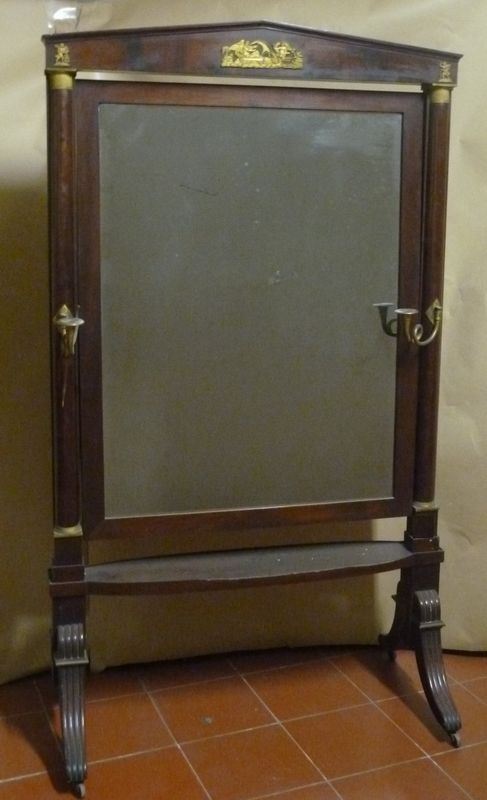 Grande specchiera a psiche, Toscana, inizi sec. XIX, in mogano con          applicazioni in bronzo dorato, cimasa sagomata a timpano, sostegni          modellati a colonna con basi e capitelli in bronzo dorato e cesellato, due  bracci portacandela, gambe scannellate a volute su rotelle in bronzo, cm    110x192