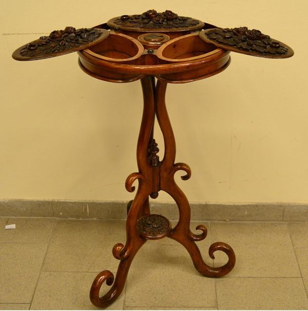 Tavolino da lavoro, inizi sec. XX, in noce intagliato a tre sportelli decorati a motivi floreali in rilievo, cm 42x85