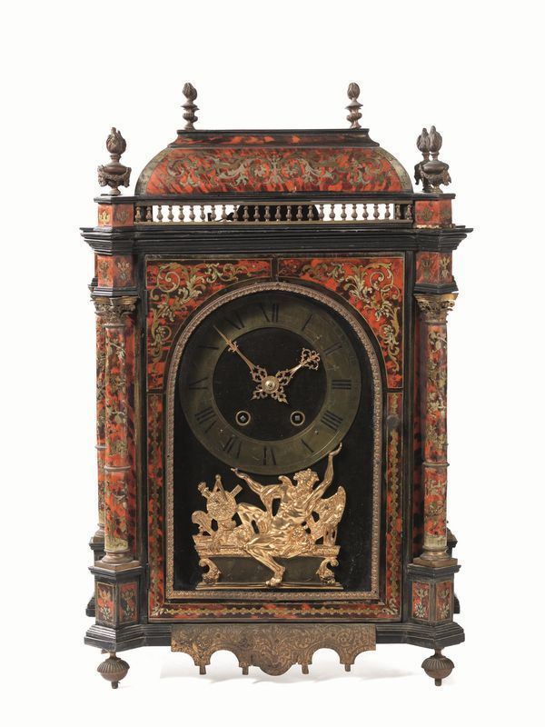 Orologio da tavolo, Francia fine sec. XVIII, cassa a parallelelepipedo in   legno tinto ad imitazione della tartaruga ed applicazioni in ottone,        interamente decorata in stile Boulle a motivi floreali, con cimasa          arricchita  da ringhiera con finali a balaustri e pinnacoli a forma di      fiamma e anfore con ghirlande, la parte centrale caratterizzata da quattro  colonne angolari con capitelli in ottone sbalzato e cesellato, fianchi e    sportello anteriore in vetro. Mostra centinata, quadrante delle ore in      ottone con cifre arabe nere e  placchetta sottostante  in bronzo sbalzato e cesellato raffigurante il Tempo nellatto di sostenere il globo, firmata     Duchesne Ã  Paris. Base sagomata con angoli smussati poggianti su quattro    piedini a trottola, pendaglina in ottone sbalzato a volute, alt. cm 61,     alcuni danni. Movimento con scappamento ad ancora, sospensione a lamina     dacciaio, carica otto giorni, suona le ore e le mezzore, da revisionare