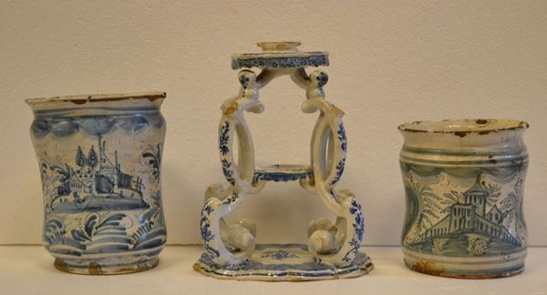Due albarelli, Napoli, sec. XVIII, in maiolica bianco-blu decorata a        paesaggi entro riserve, alt. cm 16 e cm 19, alcune sbocconcellature ed un   elemento per centrotavola, Faenza, sec. XVIII, in maiolica bianco-blu a     quattro sostegni a volute, alt. cm 24, danni (3)  - Asta Gioielli,  Argenti, Mobili, Oggetti d'arte, Dipinti ed Arte Orientale - Poggio Bracciolini Casa d'Aste