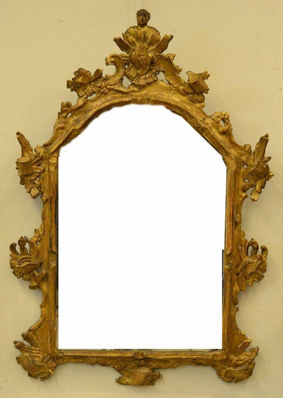 Piccola specchiera, Veneto, sec. XVIII, in legno intagliato e dorato, sormontata da busto maschile panneggiato e decorata a motivi di gusto rocaille, arricchiti da panoplie di armi, cm 107x71, specchio di epoca posteriore, alcuni danni