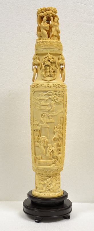 Grande vaso Cina sec. XX, con coperchio in avorio, il corpo decorato con    scene di vita quotidiana in un palazzo entro cornice sagomata, il collo del vaso intagliato con figure sotto ad un albero e lateralmente intagliate due prese modellate a cani di fo con anelli, alt. cm 52 su base in legno alt.   cm 7, restauri