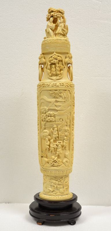 Grande vaso Cina sec. XX, con coperchio in avorio, il corpo decorato con    scene di vita quotidiana in un palazzo entro cornice sagomata, il collo del vaso intagliato con figure sotto ad un albero e lateralmente intagliate due prese modellate a cani di fo con anelli, alt. cm 52 su base in legno alt.   cm 7, restauri