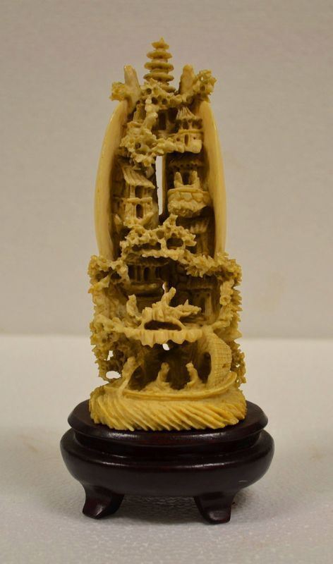 Intaglio Cina sec. XX, in avorio, raffigurante paesaggio con pagode e       personaggi, racchiuso in una conchiglia a forma ovoidale , alt. cm 15,5, su base in legno alt. cm 4