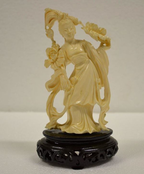 Scultura in avorio Cina sec. XX, raffigurante figura femminile con fiori di loto, alt. cm 16 su base in legno alt. cm 3,5