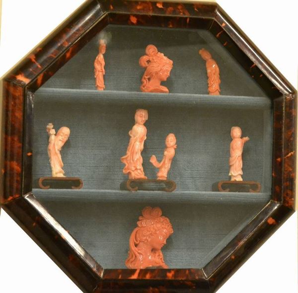 Cornice-bacheca contenente otto piccole sculture in corallo, raffiguranti figure e teste(8)