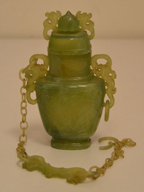 Bottiglia orientale, sec. XX, in giada incisa, con catena, alt. cm 15, difetti e mancanze