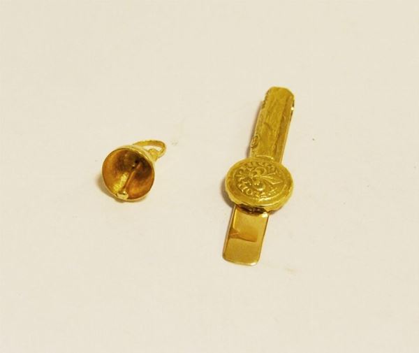Pendente in oro giallo, CAMPANELLA, g 4, marcato Torrini, e fermacravatta in oro giallo e bianco, g 7,7, marcato Torrini (2)
