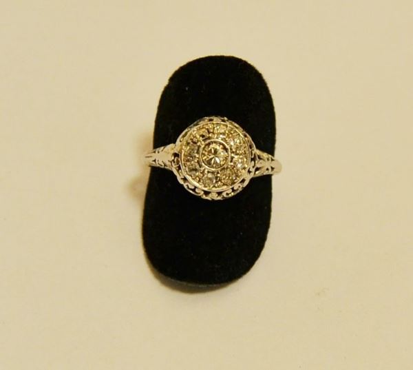 Anello in oro bianco, con corolla decorata con brillante centrale, ct. 0,15, contornato da piccoli brillanti, g 2,5