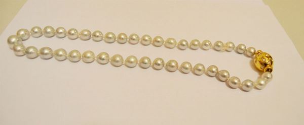 Collana di quarantuno perle barocche, con chiusura in oro decorata a brillanti