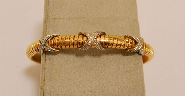 Bracciale rigido, in oro giallo e bianco, con tre elementi  incrociati decorati a brillanti, g 17,2