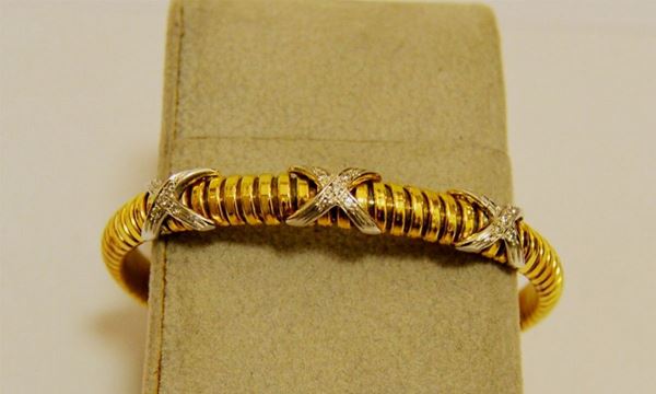 Bracciale rigido, in oro giallo e bianco, con tre elementi incrociati decorati a brillanti, g 19,5