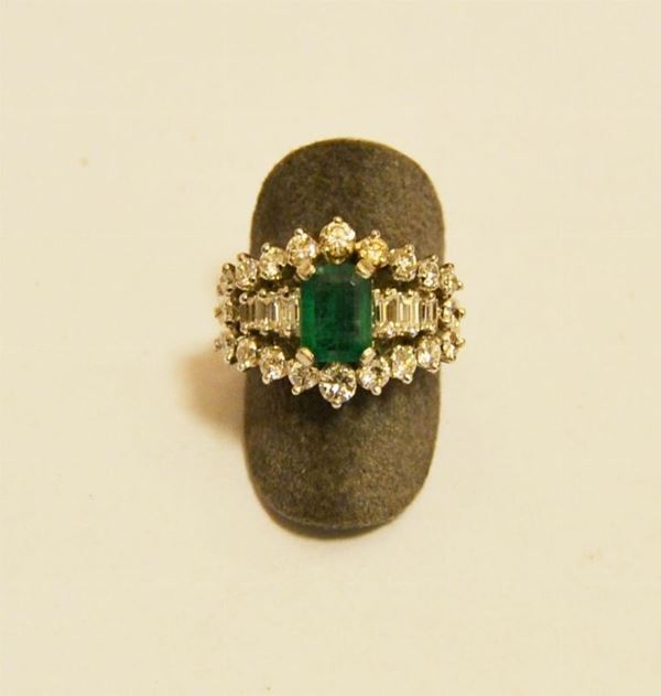 Anello in oro bianco, con smeraldo centrale e sei diamantini di taglio baguette e venti brillanti, g 9,7