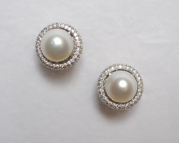 Paio di orecchini in oro bianco, perle  South Sea e diamanti ciascuno realizzato con una perla South Sea diam. mm 12 montata entro una cornice ad anello bombato in pavÃ¨ di brillanti per ct 3 circa