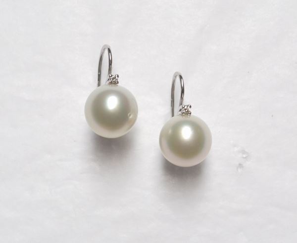 Paio di orecchini in oro bianco , perle South Sea e diamanti  ciascuno realizzato con una monachella in oro bianco su cui Ã¨ montata una perla South Sea diam mm 13 sormontata da un piccolo brillante