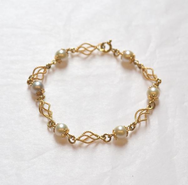 Bracciale in oro giallo e perle realizzato ad una linea di maglie fantasia in oro giallo intercalate da perle diam. mm 6,5