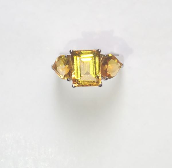 Anello in oro bianco e quarzi citrini la parte superiore decorata da un quarzo citrino taglio smeraldo affiancato da due pietre analoghe di taglio a cuore