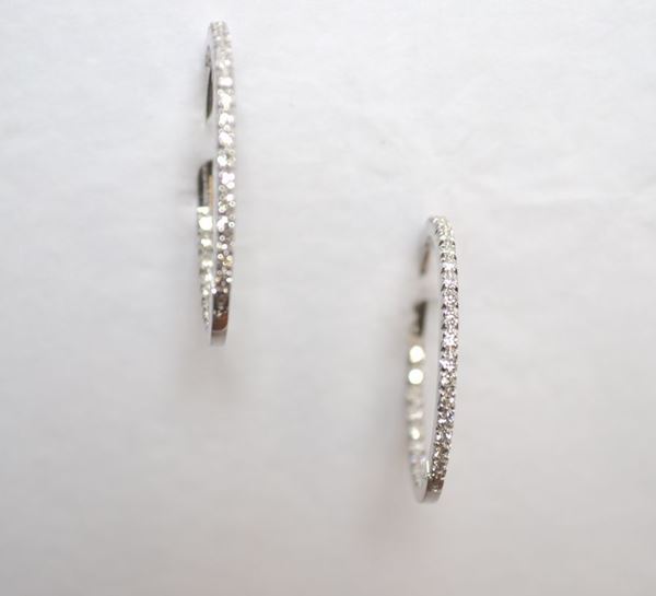 Paio di orecchini in oro bianco e diamanti ciascuno realizzato come un cerchio sottile decorato nella parte anteriore ed in quella interna da una linea di piccoli brillanti per complessivi ct 0,90 circa