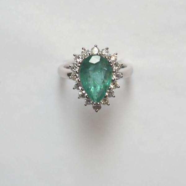 Anello in oro bianco, smeraldo e diamanti al centro uno smeraldo a goccia di ct 2,63 montato entro una cornice in brillanti per ct 0,74
