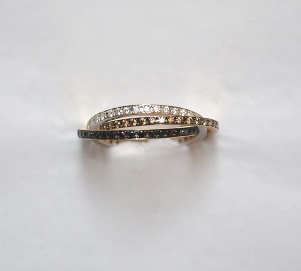 Anello in oro bianco, oro giallo, oro rosa, diamanti bianchi, neri e grigi realizzato con tre fedine nei tre colori dellâ€™oro intrecciate fra loro e rispettivamente decorate in brillanti grigi, neri e bianchi per ct 1 circa complessivi