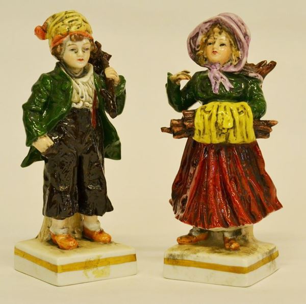 Coppia di sculture, sec. XX, in porcellana policroma, raffiguranti PORTATORI DI LEGNA, alt. cm 14,5  - Asta Gioielli,  Argenti, Mobili, Oggetti d'arte e Dipinti - Poggio Bracciolini Casa d'Aste
