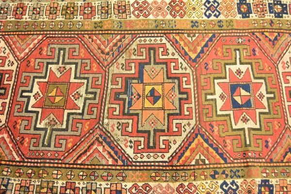 Tappeto caucasico SCIRVAN, fine sec. XIX, campo a motivo geometrico e fiori stilizzati con vari medaglioni multicolore, bordura beige e blu, cm 287x111