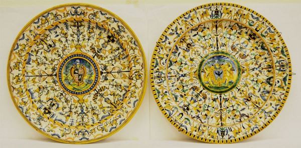Coppia di piatti da parete, inizi sec. XX, in terracotta decorata ad animali e figure, stemma centrale, cm 45,5