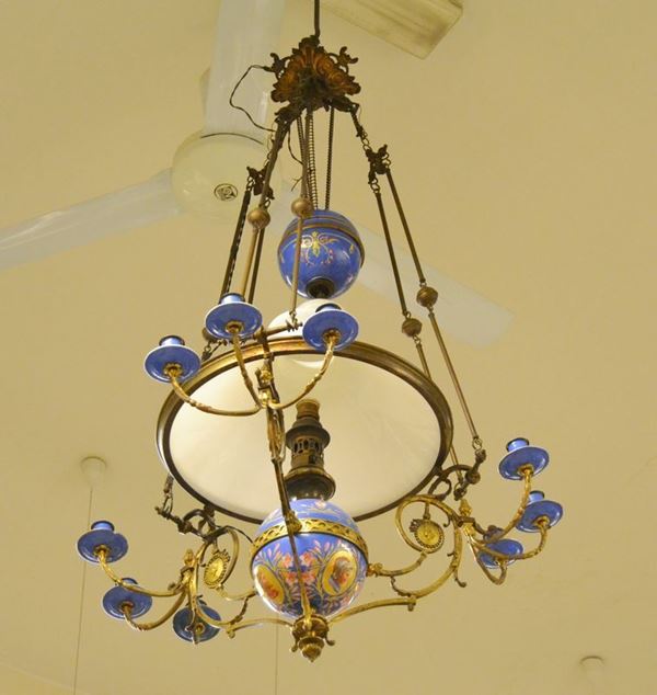 Lumiera, Francia inizi sec. XX, in metallo dorato con parti in ceramica decorata, campana in vetro
