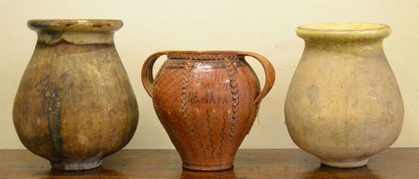 Coppia di orci da olio, in ceramica con interno smaltato, alt. cm 56 e 51, e un vaso, sec. XIX, in terracotta smaltata, con anse a nastro e due manici, reca la scritta FRATELLI BANCHINI DI CAPRAIA, alt. cm 44