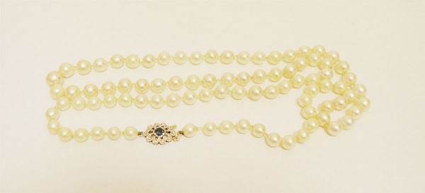 Collana realizzata ad un filo di ottantasette perle bianche, diam. da mm 7 a mm 7,5, fermatura in oro bianco con zaffiro e brillantini