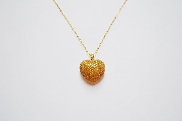Pendente in oro giallo e zaffiri gialli, modellato come un cuore bombato decorato in pavÃ© di zaffiri per ct 4,90, corredato di catena in oro giallo a maglia sottile, g 10
