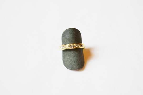 Anello in oro giallo e diamanti, la parte anteriore decorata da una linea di nove diamanti taglio princess per ct 1 circa, misura 14