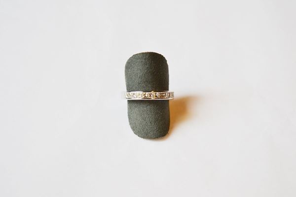 Anello in oro bianco  e diamanti, la parte anteriore decorata da una linea di undici  diamanti taglio princess per ct 0,90 circa, misura 14