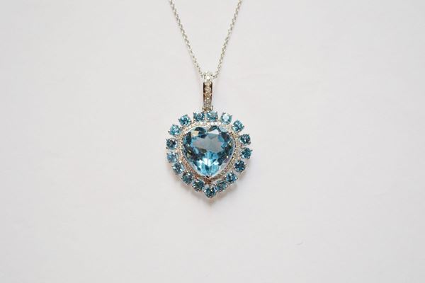 Pendente in oro bianco, topazi e diamanti, realizzato con un grande topazio azzuro tagliato a cuore montato a griffe entro una doppia cornice in piccolissimi brillanti e topazi, anello ovale in oro bianco decorato in piccoli brillanti, completo di catena in oro bianco a maglia sottile, g 10