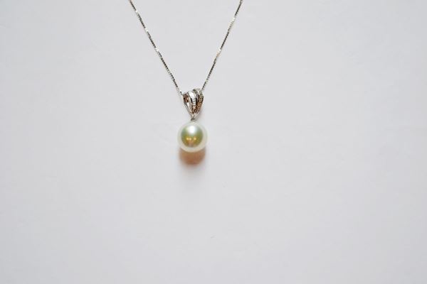 Pendente in oro bianco, diamanti e perla, realizzato con un appiccagnolo a doppi nastro decorato da diamanti baguette e brillanti a cui Ã¨ sospesa una perla South Sea mm 15,5, corredato di catena in oro bianco a maglia sottile, g 6