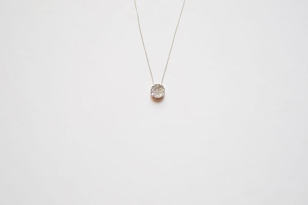 Pendente in oro bianco e diamanti, realizzato come una piccola corolla circolare decorata in brillanti per ct 0,46, completo di catena a maglia sottile in oro bianco, g 2