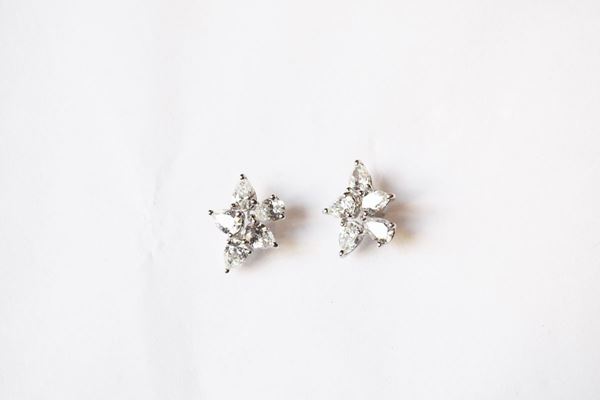 Paio di orecchini in oro bianco e diamanti, ciascuno disegnato come una piccola corolla stilizzata formata da cinque brillanti di taglio a goccia per complessivi ct 1,40 circa