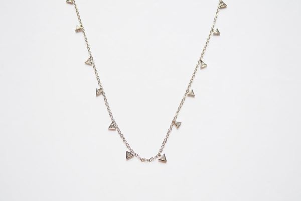 Collana girocollo in oro bianco e diamanti realizzato con una catena a maglia sottile a cui sono sospesi quindici diamanti di taglio triangolare per ct 1,40 circa, g 5