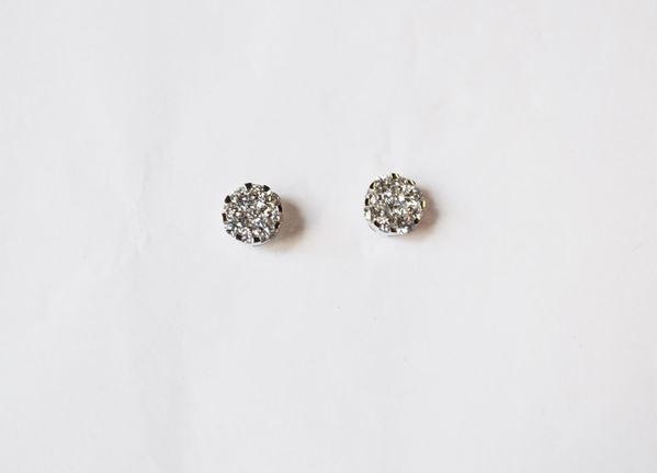 Paio di orecchini in oro bianco e diamanti, ciascuno realizzato come una piccola corolla decorata in brillanti per ct 0,80 circa, g 2