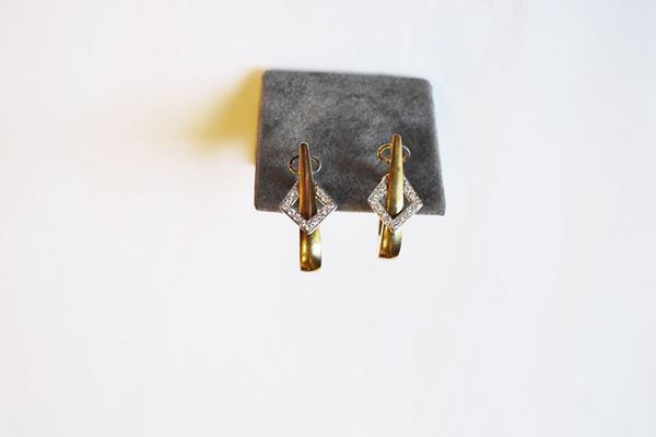 Paio di orecchini in oro giallo, oro bianco e diamanti                      ciascuno disegnato come un semianello bombato ovale in oro giallo decorato  da un motivo romboidale in oro bianco e piccoli brillanti