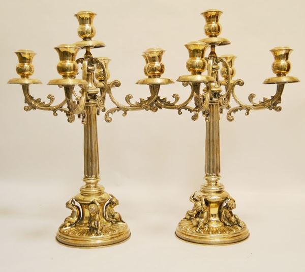 Due candelieri in argento, sec. XIX, a cinque portacandele, con colonna centrale scanalata sorretta da putti, g 5710 ( 2 )