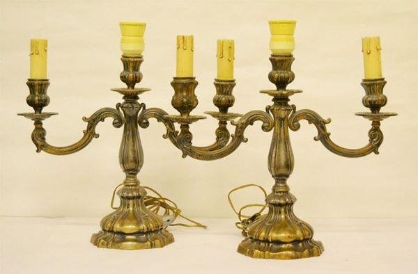 Due candelieri, sec. XX, a tre luci, in argento cesellato, completi di applicazione elettrica, g 1200 lordi ( 2 )
