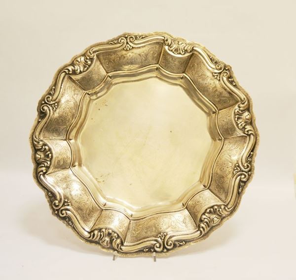 Vassoio rotondo, sec. XX, in argento, con bordo sagomato, sbalzato e inciso, diam. cm 51, g 1840