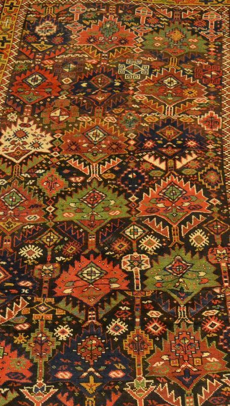 Tappeto caucasico SCIRVAN, sec. XIX, campo a motivo geometrico e fiori stilizzati, fondo blu notte, con vari medaglioni multicolori a tutto campo, bordura senape e blu, cm 260x140