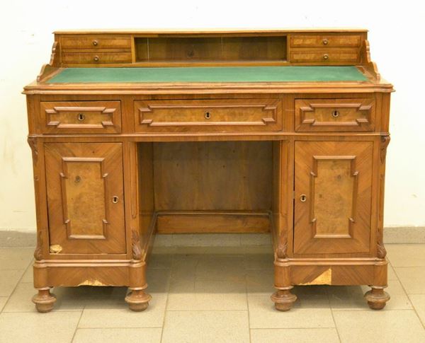 Scrivania da centro, sec. XIX, in noce, due sportelli, sette cassetti e piano in panno verde, cm 128x70x97, da restaurare