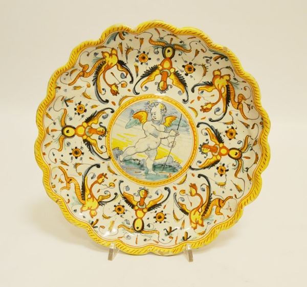 Alzata, Deruta sec. XVIII, in maiolica pitturata e decorata, con al centro putto, diam. cm 25, base da restaurare, mancanze